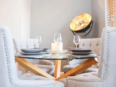 a dining room table with chairs and a mirror at Woodbridge Penthouse in Woodbridge