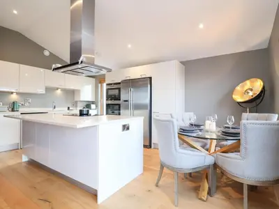 a kitchen and dining room with a table and chairs at Woodbridge Penthouse in Woodbridge
