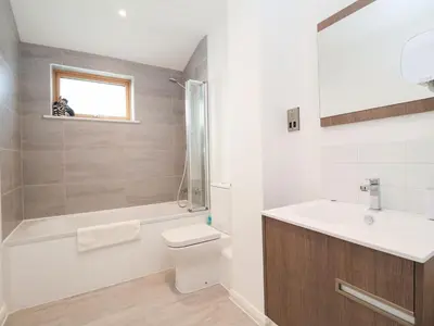 a bathroom with a toilet and a sink and a shower at Woodbridge Penthouse in Woodbridge