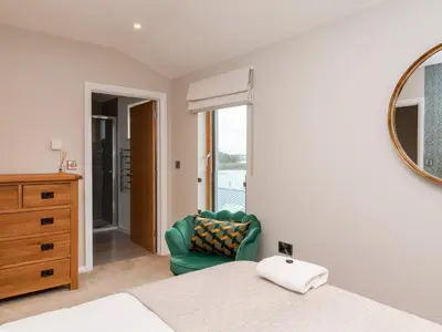 a bedroom with a green chair and a mirror at Woodbridge Penthouse in Woodbridge