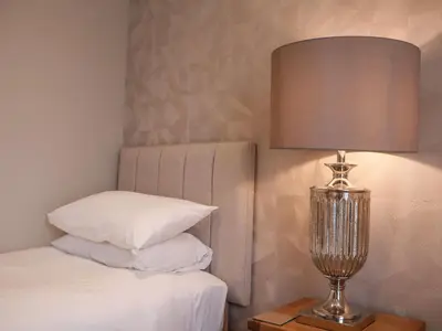 a bedroom with a bed and a lamp on a table at Woodbridge Penthouse in Woodbridge