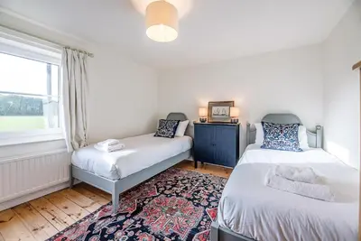 a bedroom with two beds and a window at Solebay House, Tunstall in Woodbridge