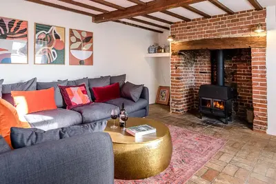 a living room with a couch and a fireplace at Solebay House, Tunstall in Woodbridge