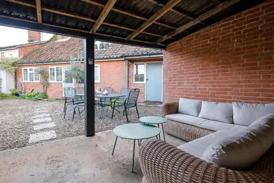 a patio with a couch and a table and chairs at Solebay House, Tunstall in Woodbridge