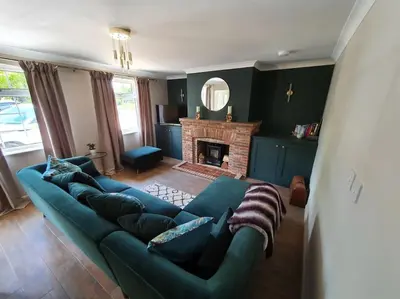 a living room with a blue couch and a fireplace at Belle Vue Cottage in Downham Market
