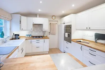 a white kitchen with white cabinets and a sink at 18 Hartington, Aldeburgh in Aldeburgh