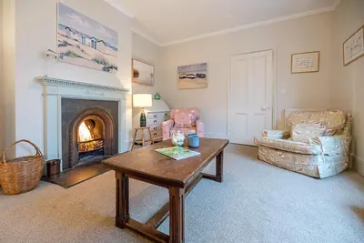 a living room with a table and a fireplace at 18 Hartington, Aldeburgh in Aldeburgh
