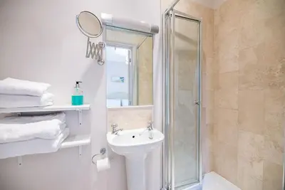 a bathroom with a shower and a sink and a mirror at 18 Hartington, Aldeburgh in Aldeburgh