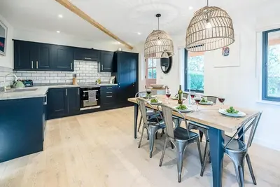 a kitchen with a large wooden table and chairs at Little Bramble, Orford in Orford