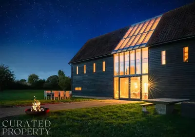 a barn at night with the lights on at Grand Suffolk Barn Conversion in Chelsworth