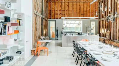 a kitchen and dining room with white tables and chairs at Grand Suffolk Barn Conversion in Chelsworth