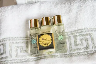 three bottles of essential oils sitting on a towel at Deluxe 2 Bed Versace Bungalow Hot Tub, Sky TV, Cinema Screen Saffron Walden in Saffron Walden