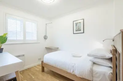 a white bedroom with a bed and a window at Modern & Private - Free Parking in Cherry Hinton