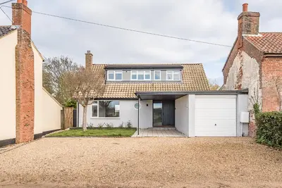 a brick house with a white garage at Chapel House, Alderton in Woodbridge