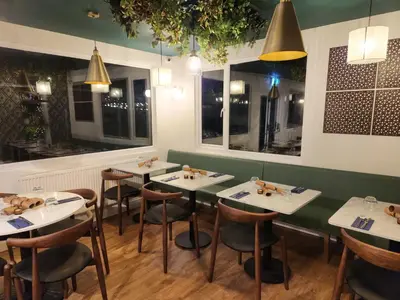 a restaurant with white tables and chairs and lights at The Swan - A Colombo Edition Hotel in Ely