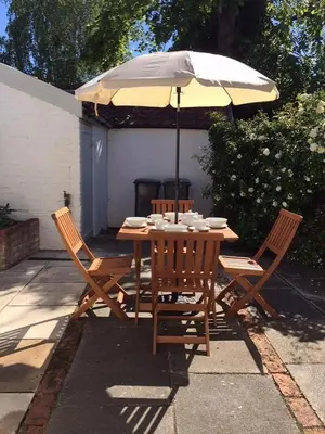 a table and chairs with an umbrella on a patio at 2 Bed in Eye oc-4lamb in Eye