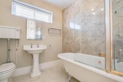 a bathroom with a tub and a toilet and a sink at 2 Bed in Eye oc-4lamb in Eye