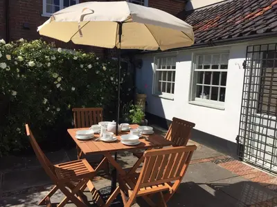 a wooden table and chairs under an umbrella at 2 Bed in Eye oc-4lamb in Eye