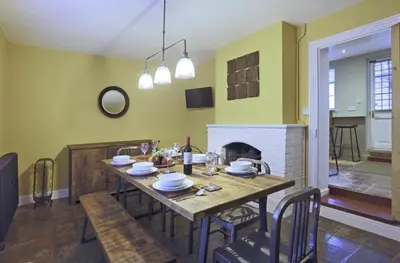 a dining room with a table and a fireplace at 2 Bed in Eye oc-4lamb in Eye