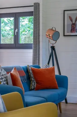 a blue couch with orange pillows in a living room at 2 Bed in Stradbroke oc-wopl in Stradbroke