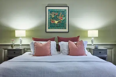 a large bed with pink and white pillows at The Mistley Thorn in Mistley