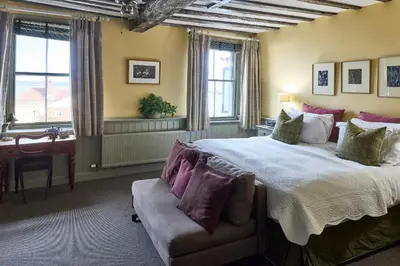 a bedroom with a large bed and a desk at The Mistley Thorn in Mistley