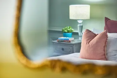 a bedroom with a bed with a table with a lamp at The Mistley Thorn in Mistley