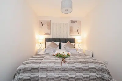 a bedroom with a large bed with flowers on it at Stunning 2-Bed Apartment in Stevenage, Sleeps 5 with free Private Parking in Stevenage