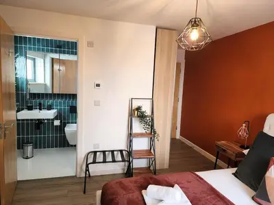 a bedroom with a bed and a bathroom with a sink at Luxury Station Apartment in Cambridge