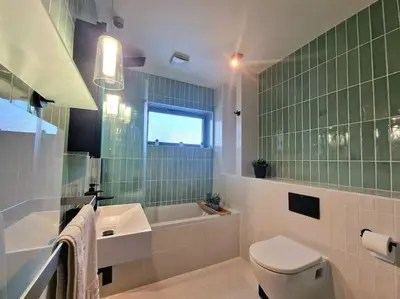a bathroom with a toilet and a tub and a sink at Luxury Station Apartment in Cambridge