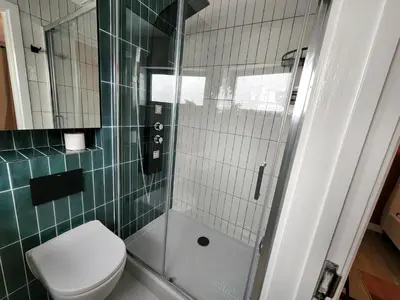 a bathroom with a toilet and a glass shower at Luxury Station Apartment in Cambridge