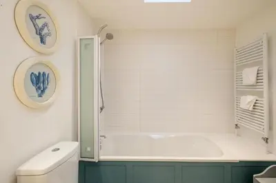 a bathroom with a bath tub and a toilet at 9 Uplands in Thorpeness