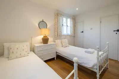 two twin beds in a bedroom with a mirror at 9 Uplands in Thorpeness
