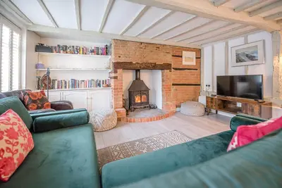 a living room with a couch and a fireplace at Jenny Rose Cottage, Wickham Market in Woodbridge