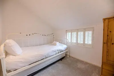 a white bed in a room with a window at Jenny Rose Cottage, Wickham Market in Woodbridge