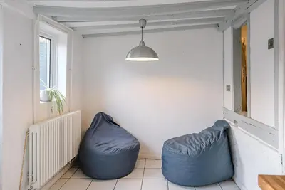 a room with two blue bean bags sitting next to a window at Jenny Rose Cottage, Wickham Market in Woodbridge