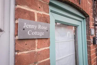 a sign on the side of a brick building at Jenny Rose Cottage, Wickham Market in Woodbridge