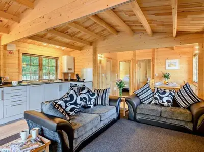 a living room with two couches and a kitchen at Hulver Lodge, Snape, Suffolk. in Snape