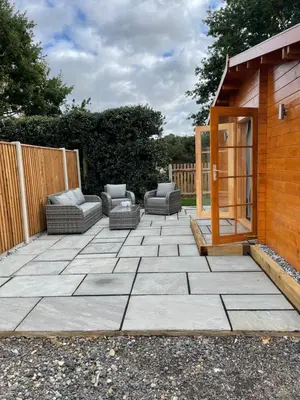 a patio with couches and a wooden building at Hulver Lodge, Snape, Suffolk. in Snape