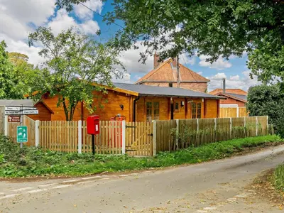 a wooden house with a fence in front of it at Hulver Lodge, Snape, Suffolk. in Snape