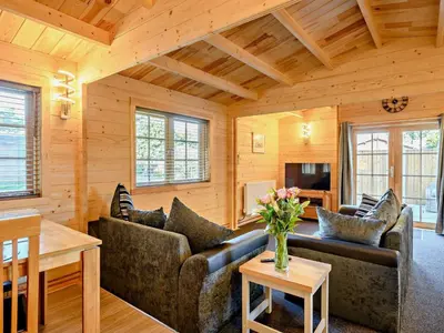 a living room with a couch and a table at Hulver Lodge, Snape, Suffolk. in Snape