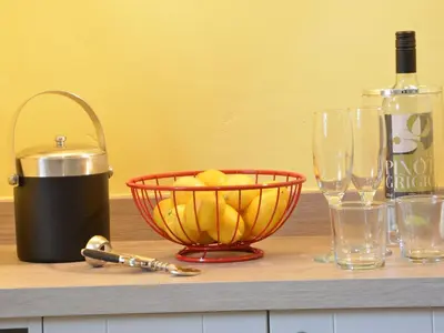a counter with a bowl of bananas and wine glasses at Crabbe Corner in Aldeburgh