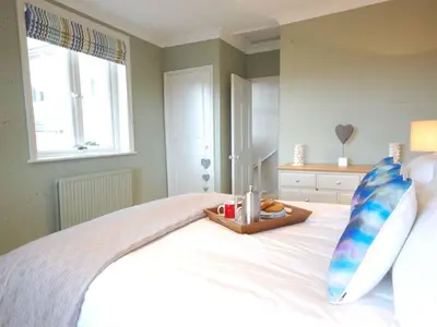 a bedroom with a bed with a tray of food on it at Crabbe Corner in Aldeburgh