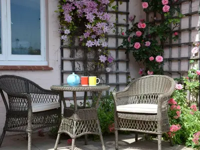 a table with two chairs and a table with a cup on it at Crabbe Corner in Aldeburgh