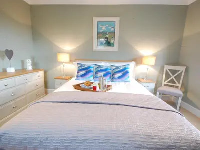 a bedroom with a bed with a tray of books on it at Crabbe Corner in Aldeburgh