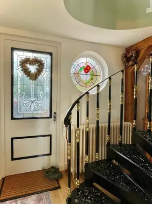 a room with stairs and a stained glass window at The Millers Cottage in Cambridge