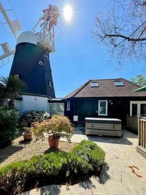 a house with a windmill in the back yard at The Millers Cottage in Cambridge