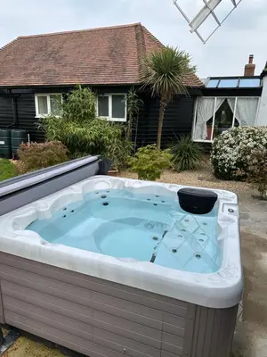 a hot tub in the yard of a house at The Millers Cottage in Cambridge