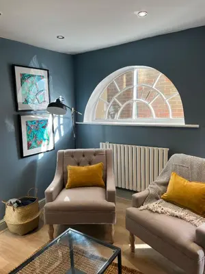 a living room with two chairs and a window at The Barn in Saxmundham
