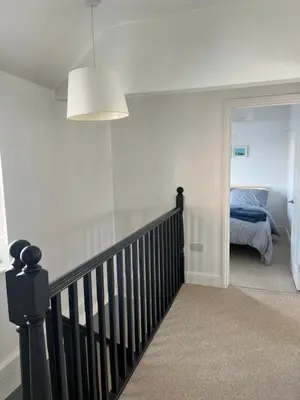 a hallway with a staircase and a bed in a room at The Barn in Saxmundham